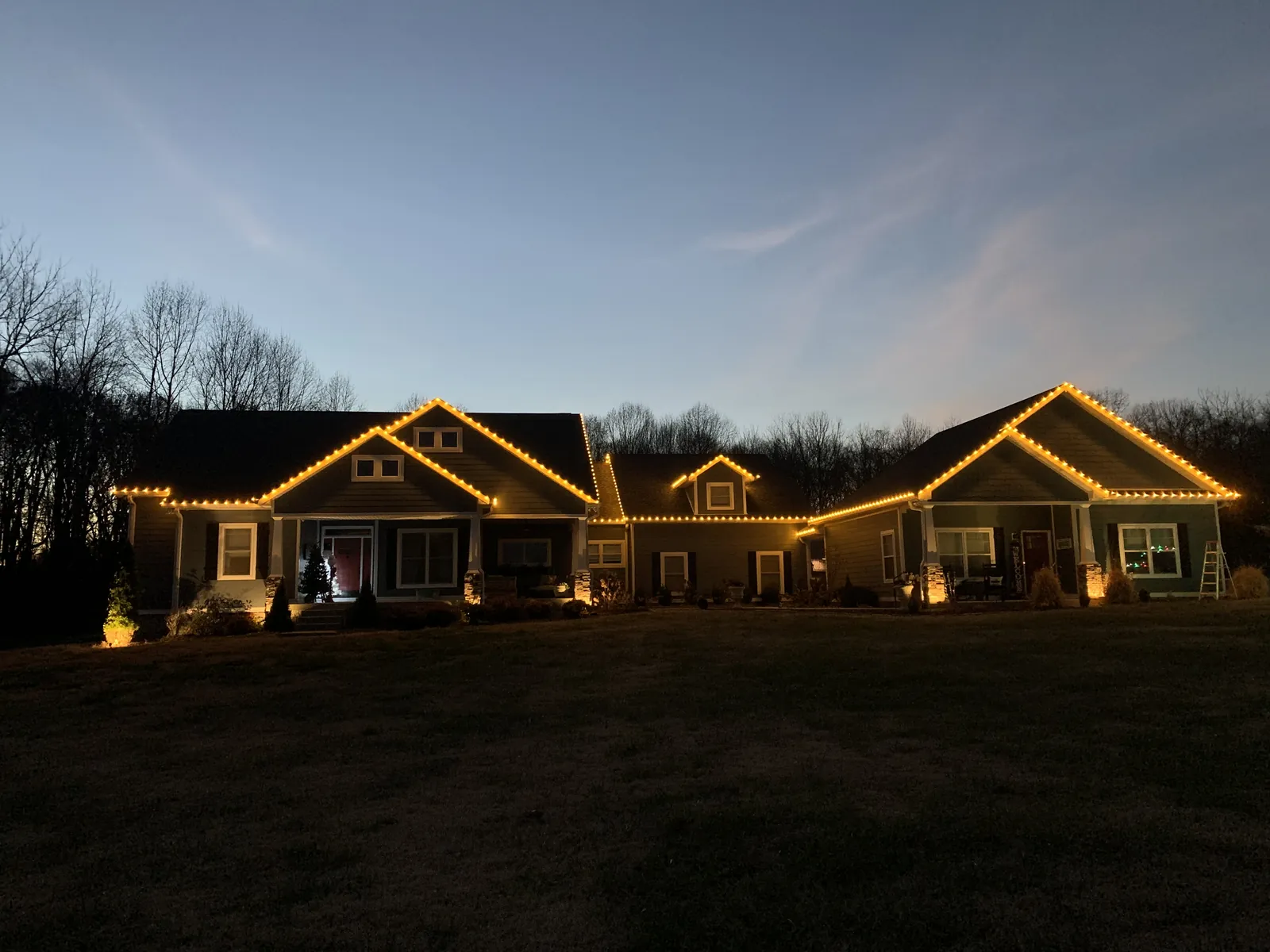 A long single story roofline lit warm white against a dusk sky
